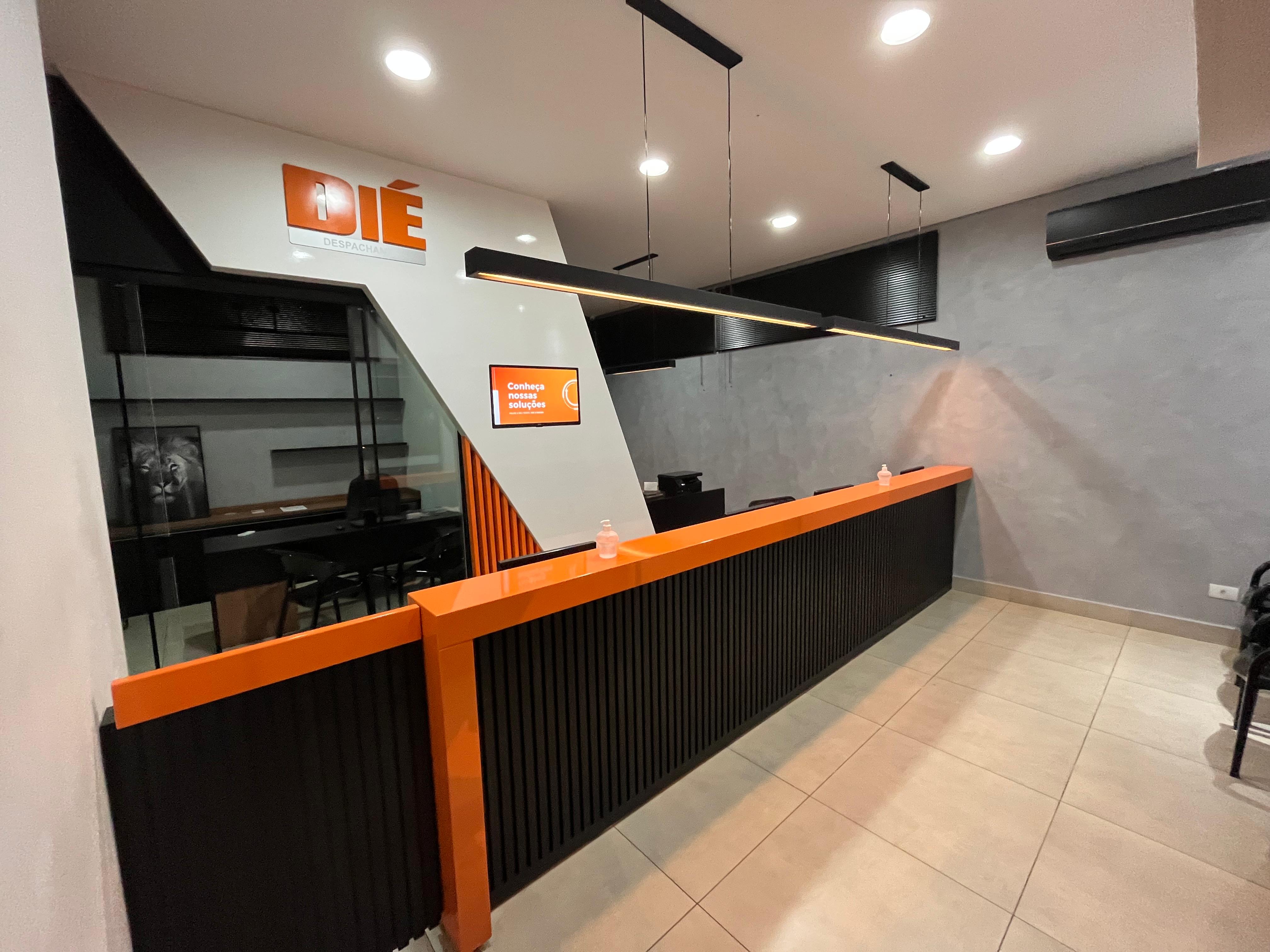 Recepção da Dié Despachante, com balcão laranja e ambiente moderno